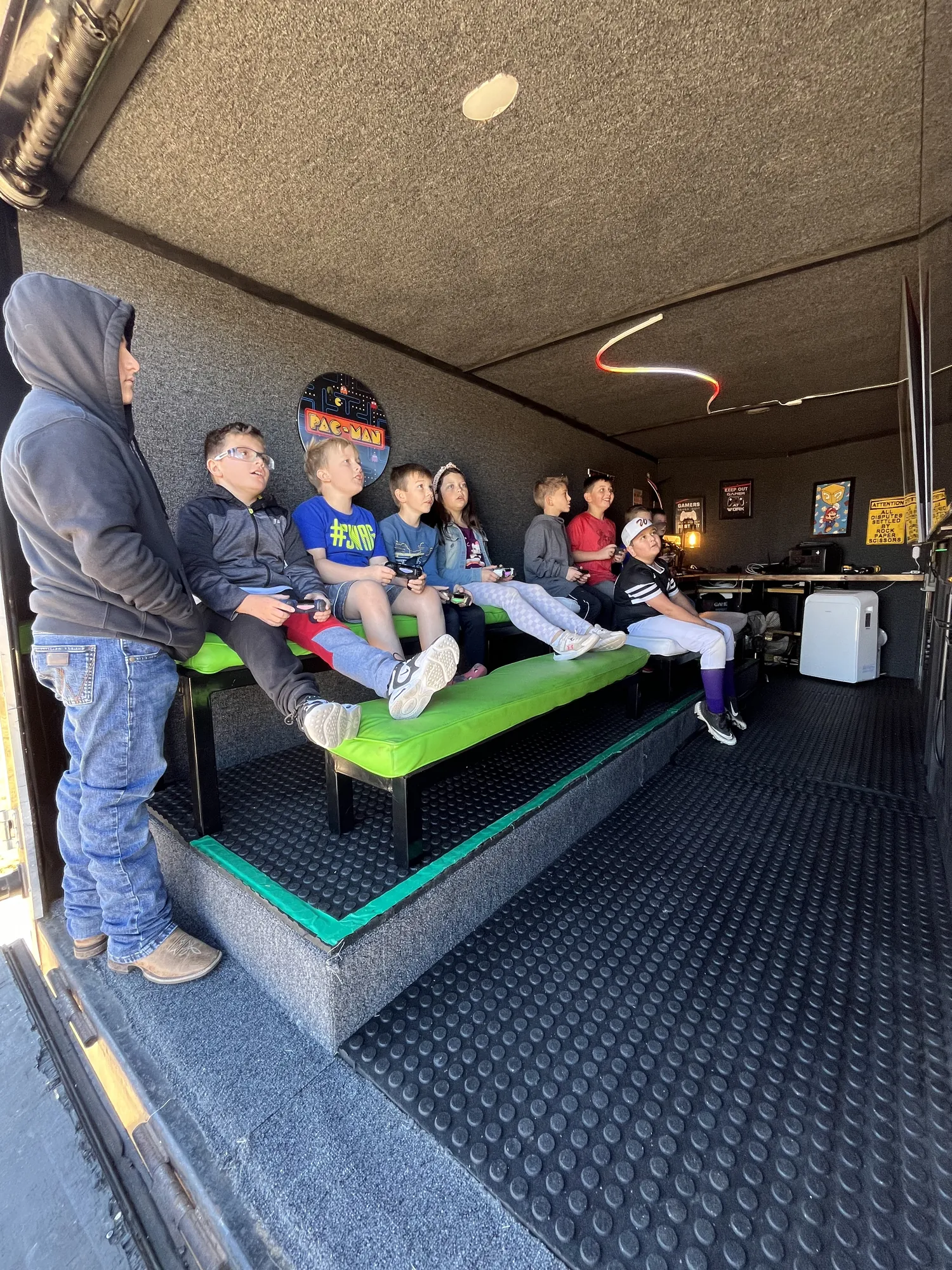Kids sitting on the steps and benches at the open door of the trailer