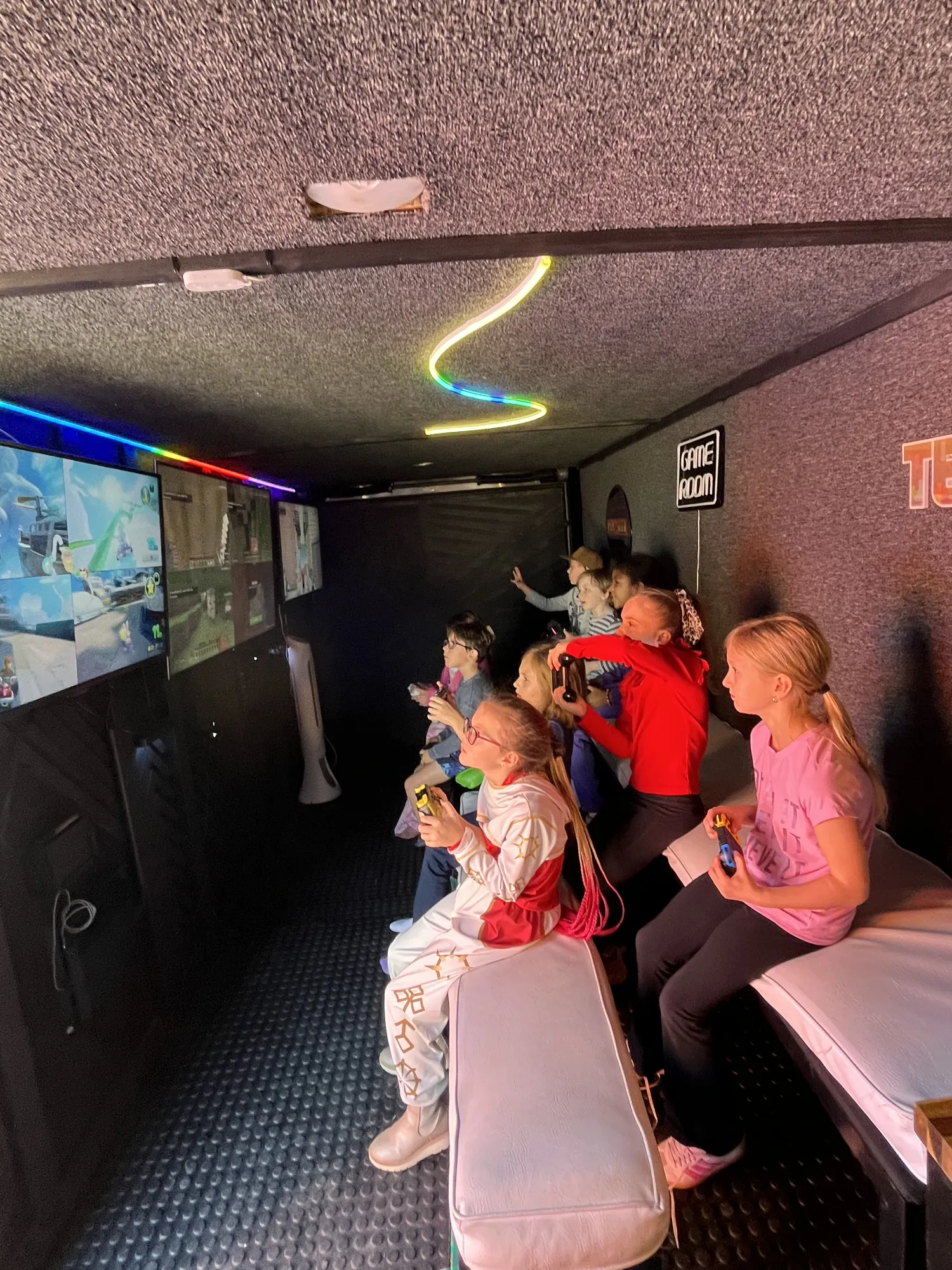 Girls racing each other on the big screens inside the game trailer