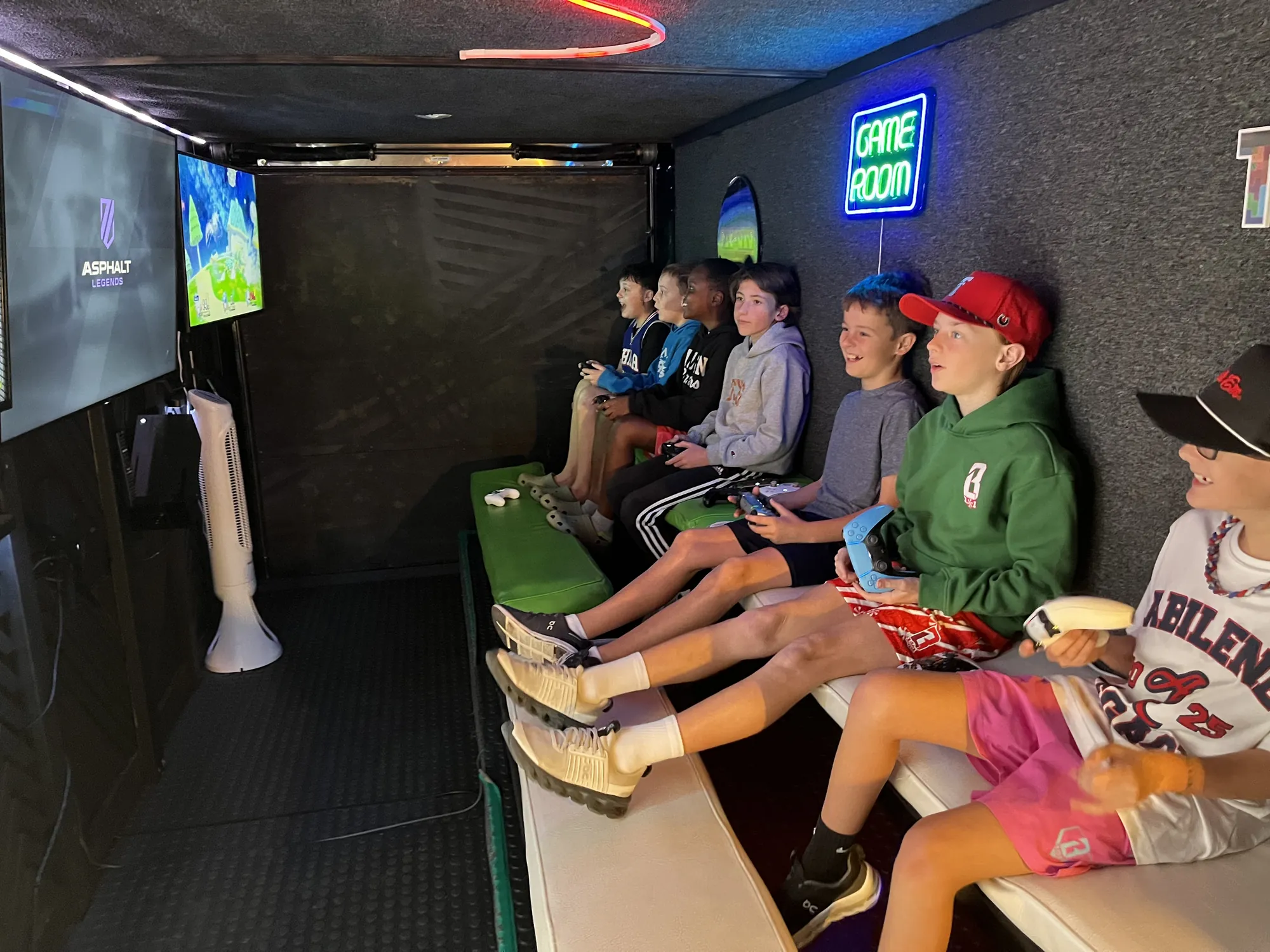 Kids laughing and playing together on the benches inside the trailer