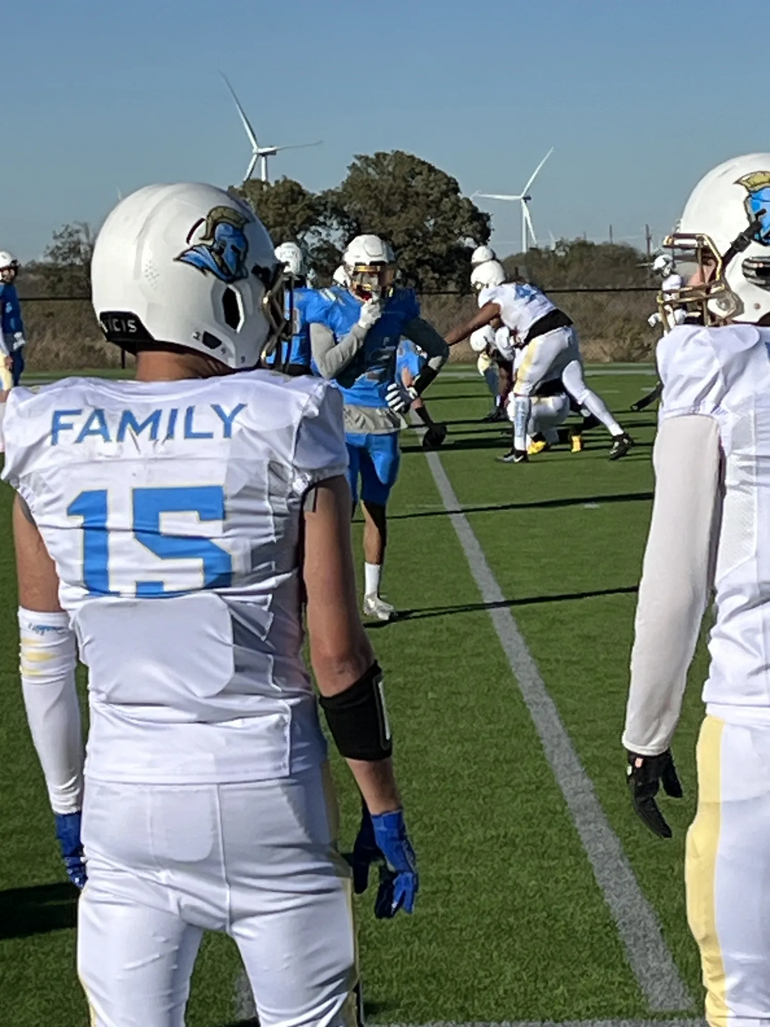 Abilene Gladiators football players in white and light blue uniforms on the field