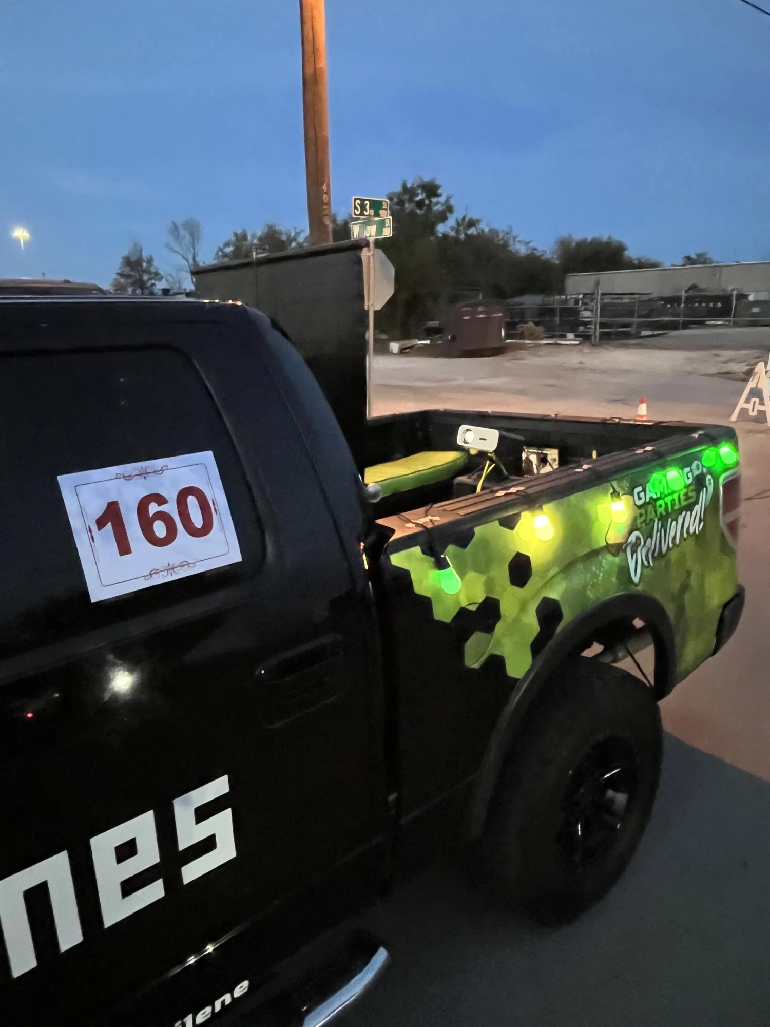 The Green Games truck wearing a parade number and green lights, lined up for the FOX West Texas Christmas Lights Parade