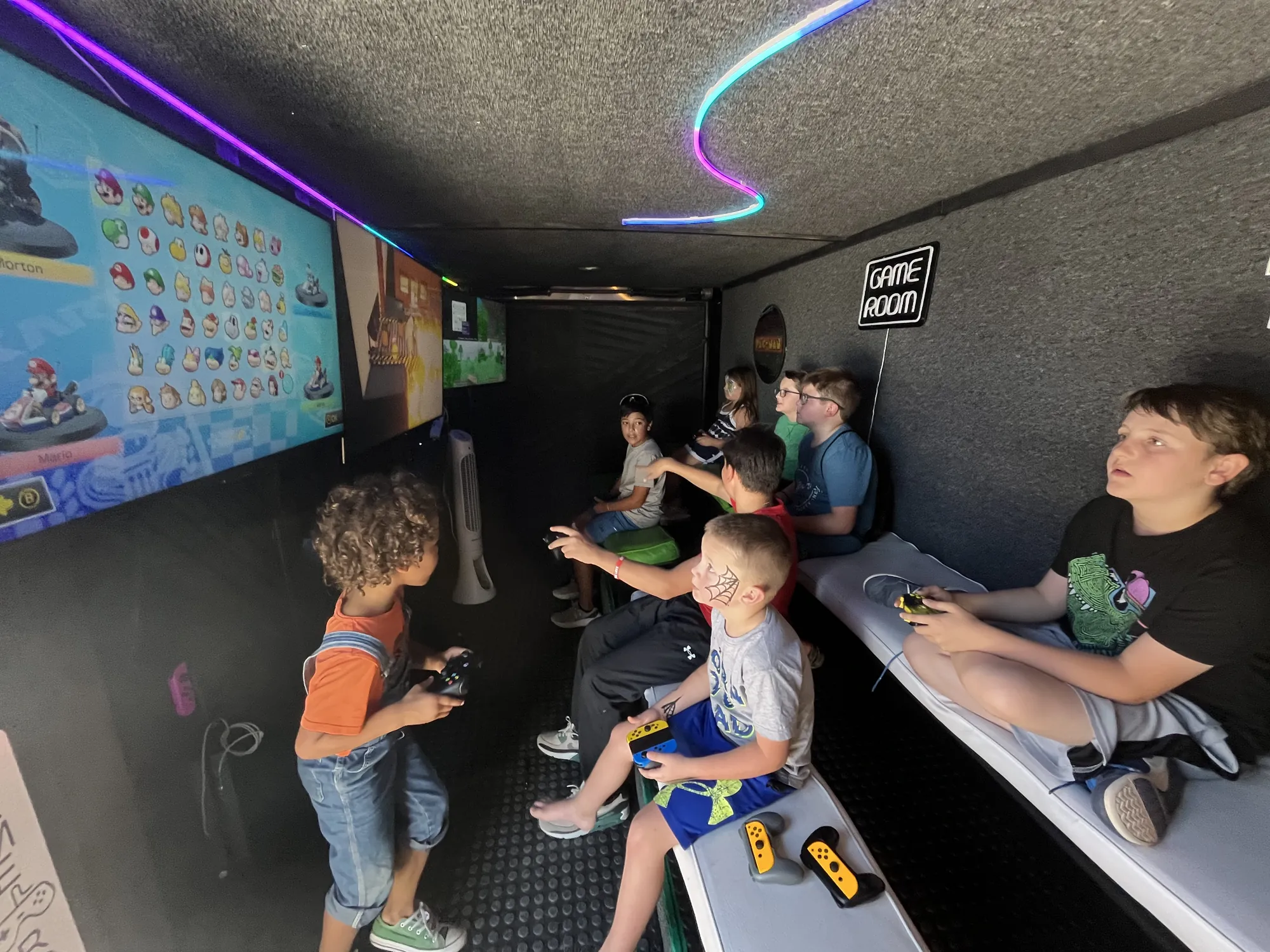 Kids of all ages playing video games inside the trailer at a soccer complex grand opening