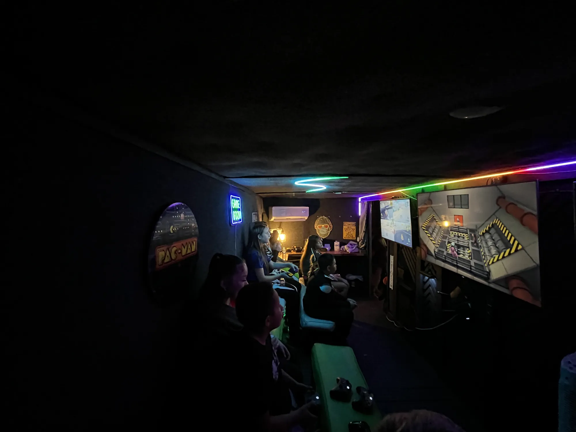 Players silhouetted against the glowing screens inside the trailer at night