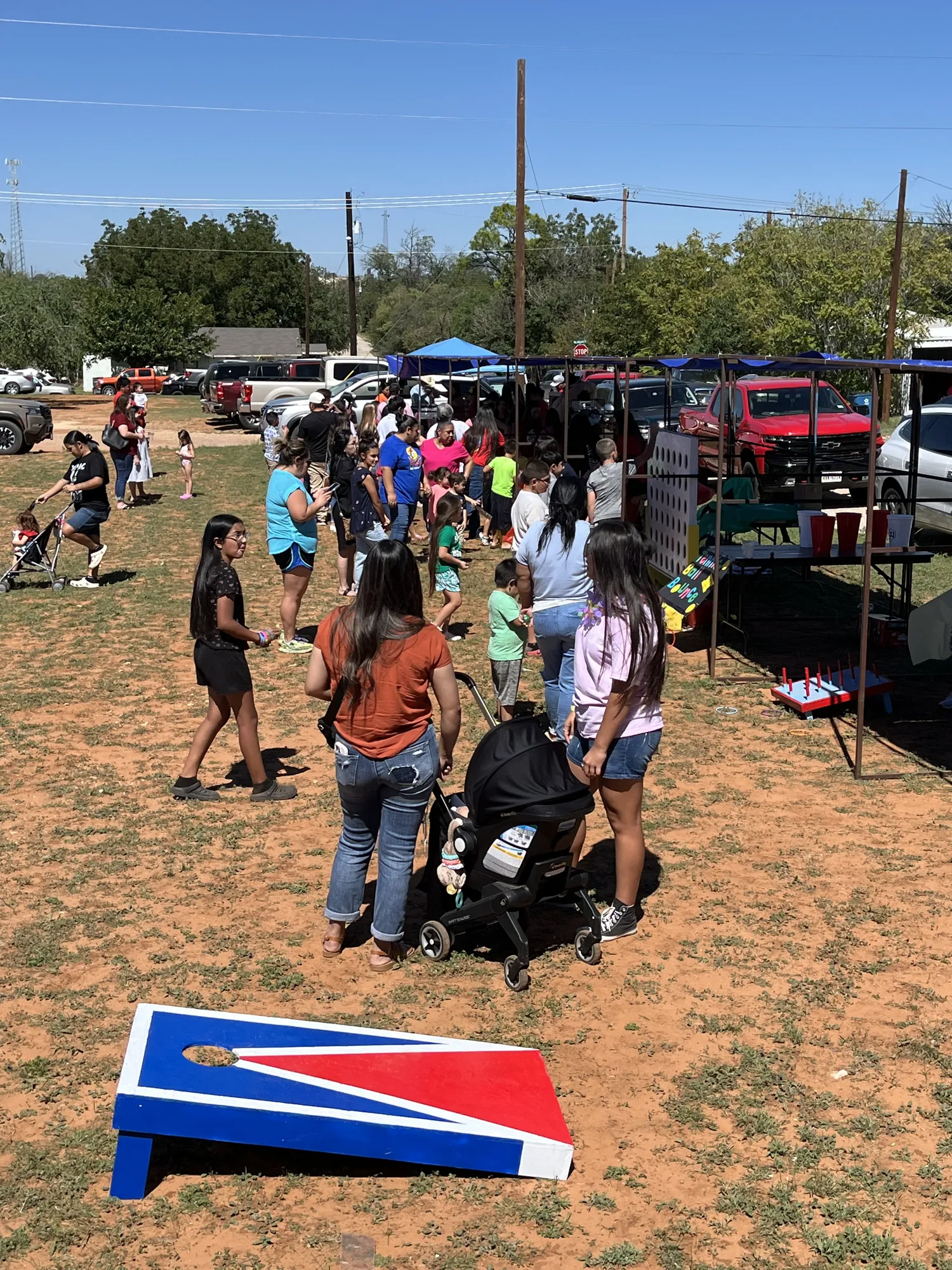 Kids and families crowding the festival grounds around carnival games at a church fall festival