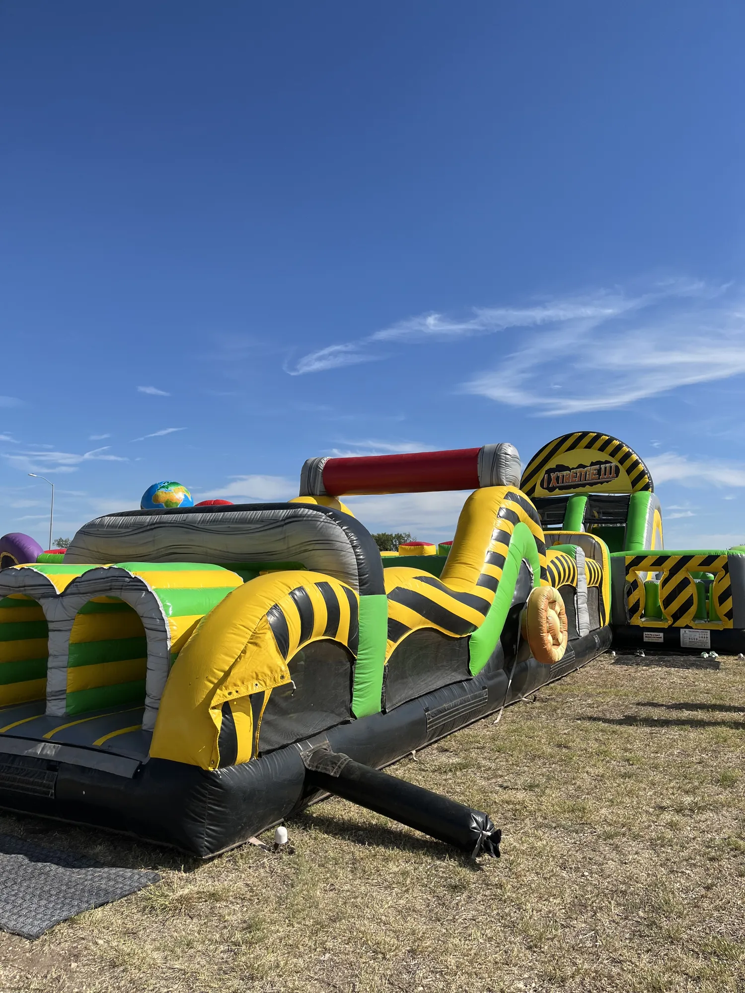 A bright inflatable obstacle course set up on the grass at a fall event