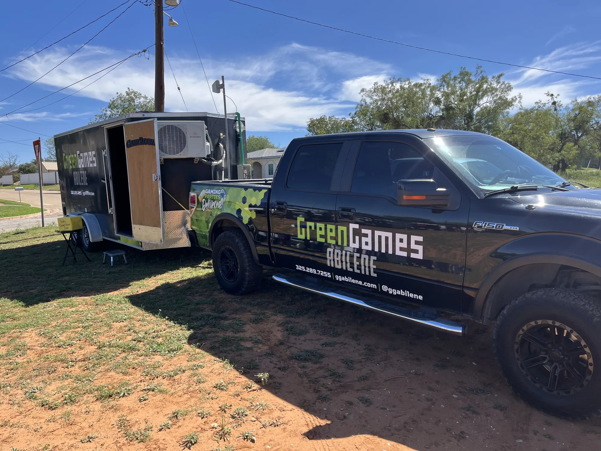 The Green Games truck and video game trailer parked on the grass at a church fall festival in Sweetwater