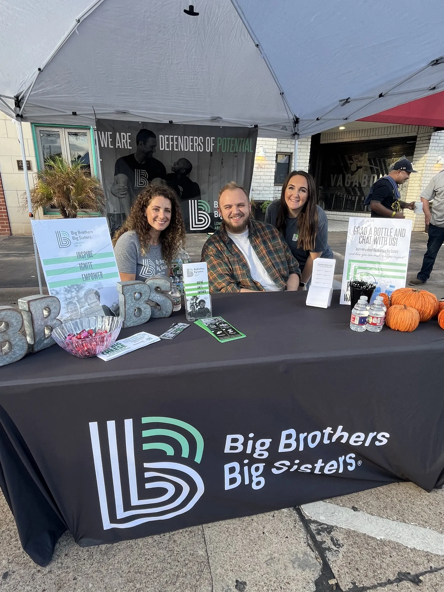 Volunteers smiling at the Big Brothers Big Sisters booth