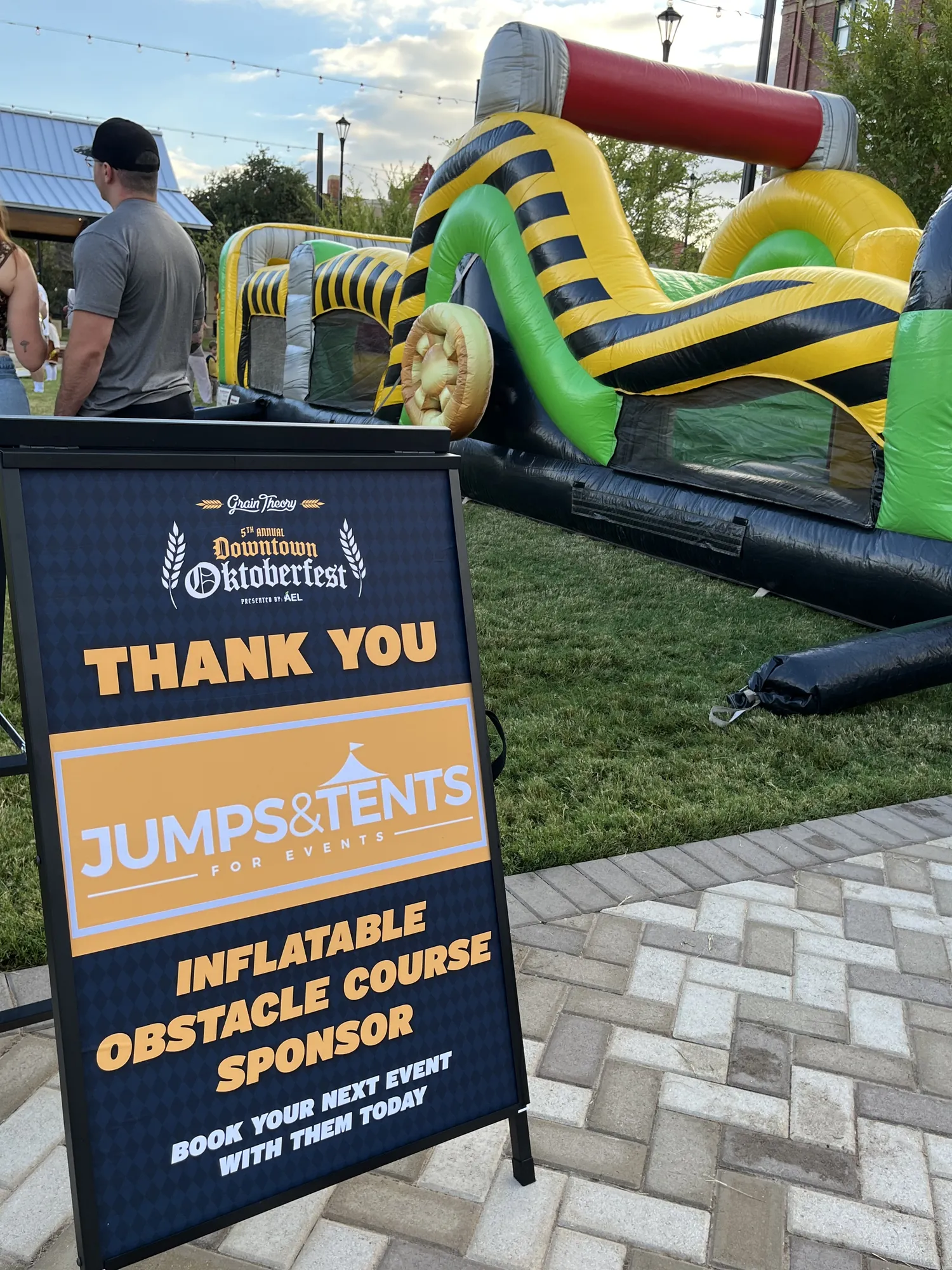 Inflatable obstacle course with a sign thanking Jumps & Tents for Events as its sponsor