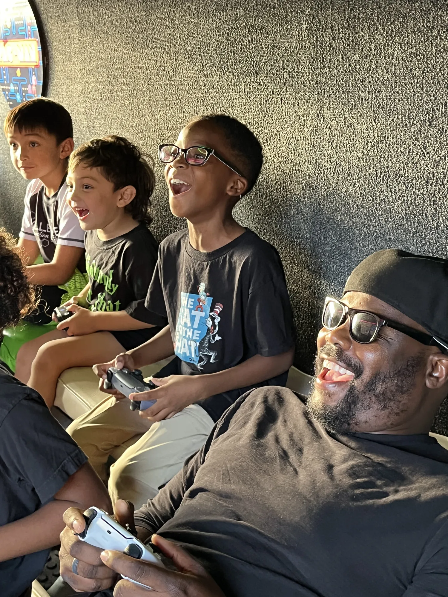 Kids and a grown-up laughing while they play video games together in the trailer