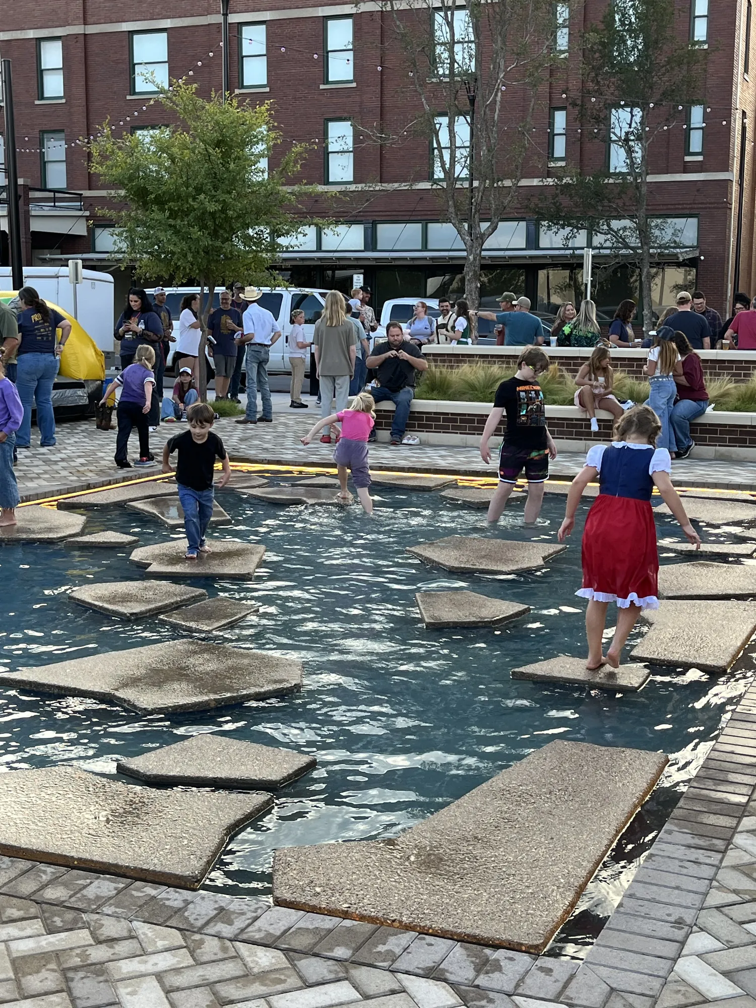 Kids crossing the stepping stones in the Cypress Plaza fountain