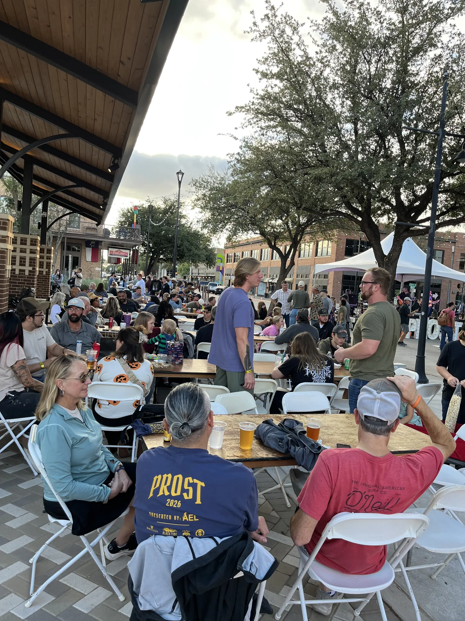 A crowd of friends and families at tables downtown